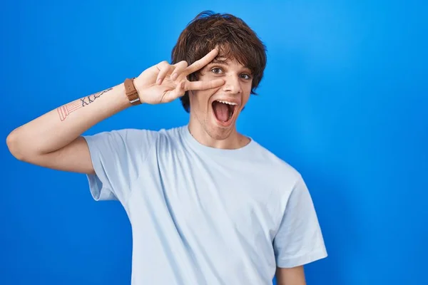 Hispanic Young Man Standing Blue Background Doing Peace Symbol Fingers — Stok fotoğraf