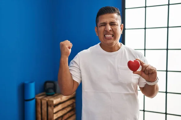 Латиноамериканец Держит Красное Сердце Спортзале Гордо Крича Празднуя Победу Успех — стоковое фото