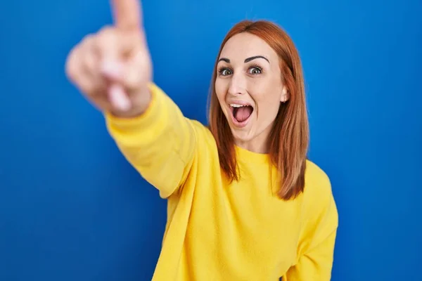 Young Woman Standing Blue Background Pointing Finger Surprised Ahead Open — Stockfoto