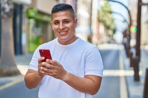 Jonge Latijnse Man Glimlacht Vol Vertrouwen Met Behulp Van Smartphone — Stockfoto