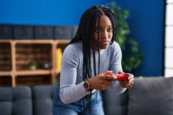 非洲裔美国妇女在家里玩集中表达的电子游戏 — 图库照片