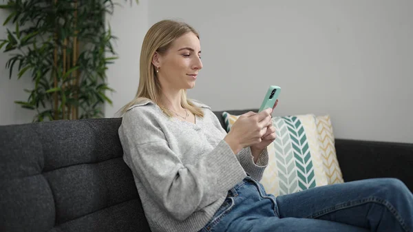 Mladá Blondýna Žena Pomocí Smartphone Sedí Pohovce Doma — Stock fotografie