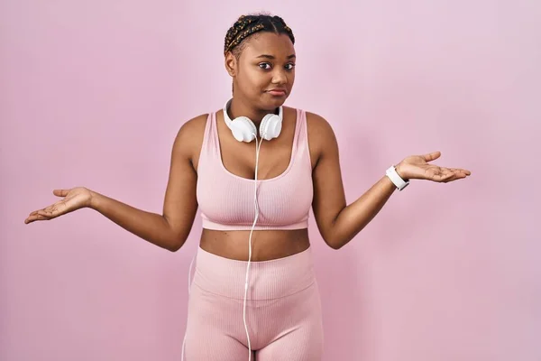 Afroamerikanerin Mit Zöpfen Sportkleidung Und Kopfhörern Ahnungslos Und Verwirrt Mit — Stockfoto
