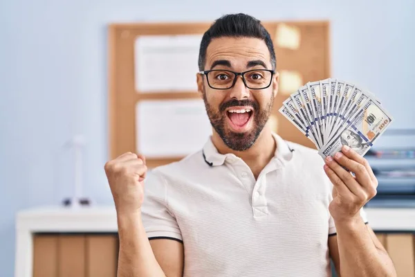 Jovem Hispânico Com Barba Óculos Segurando Notas Dólar Gritando Orgulhoso — Fotografia de Stock