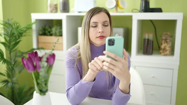 Evde Masada Oturan Akıllı Telefon Kullanan Genç Sarışın Kadın — Stok fotoğraf