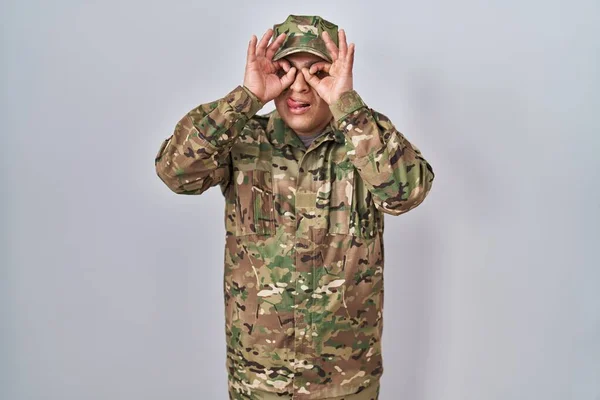 Latynoski Młodzieniec Mundurze Wojskowym Wykonujący Gest Jak Lornetka Wystająca Języka — Zdjęcie stockowe
