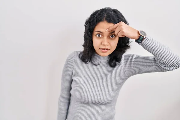 暗い髪を孤立した背景の上に立っているヒスパニック系の女性額ににきびに不幸な指して 黒頭の醜い感染症 にきびや皮膚の問題 — ストック写真