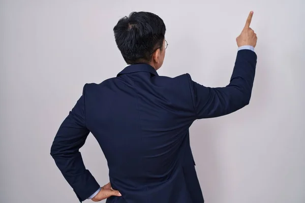 年轻的亚洲人穿着西服 打着领带 背对背 手指头指向前方 — 图库照片