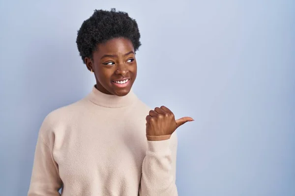 Afroamerykanka Stojąca Nad Niebieskim Tłem Uśmiechnięta Szczęśliwą Twarzą Patrzącą Wskazującą — Zdjęcie stockowe