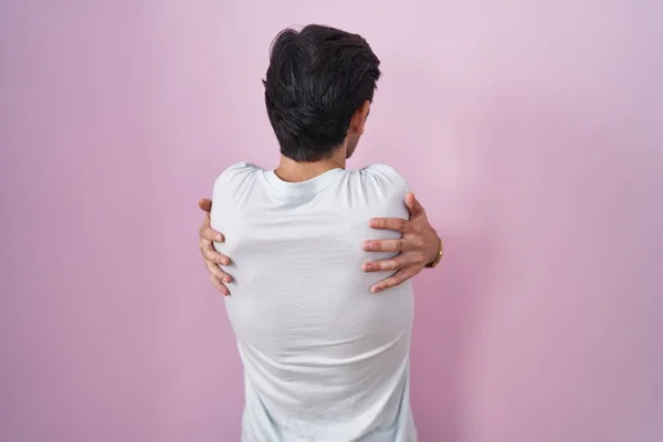 Νεαρός Ισπανός Που Στέκεται Πάνω Από Ροζ Φόντο Αγκαλιάζοντας Τον — Φωτογραφία Αρχείου