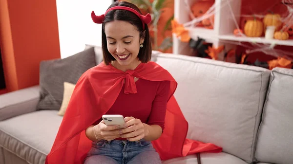 Young Beautiful Hispanic Woman Wearing Devil Costume Using Smartphone Home — Fotografia de Stock