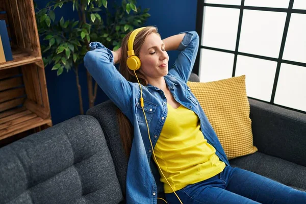 Young Blonde Woman Listening Music Sitting Sofa Home — Zdjęcie stockowe