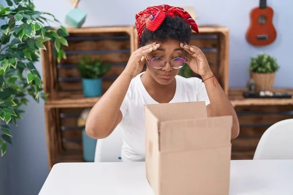 アフリカ系アメリカ人の女性が家庭で不幸な表情で段ボール箱を開梱 — ストック写真