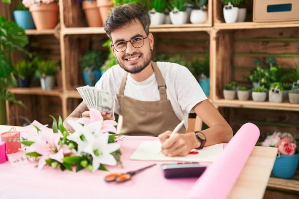 Young Hispanic Man Florist Counting Dollars Writing Notebook Flower Shop — Stock Fotó