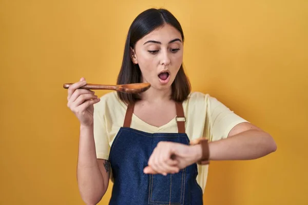 Latynoska Dziewczyna Jedząca Zdrową Drewnianą Łyżkę Patrząc Zegarek Zmartwiona Bojąc — Zdjęcie stockowe