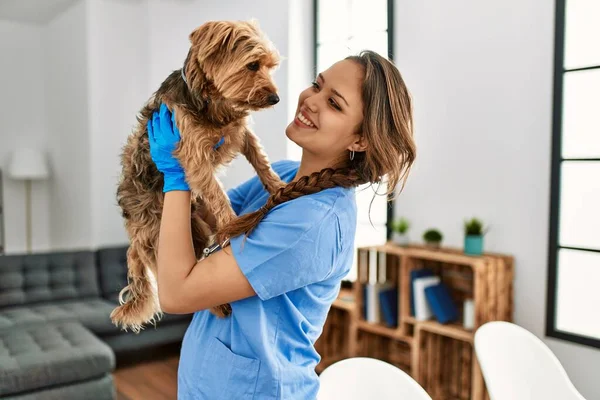 年轻美丽的惊慌失措的女兽医微笑着 自信地把狗抱在家里 — 图库照片