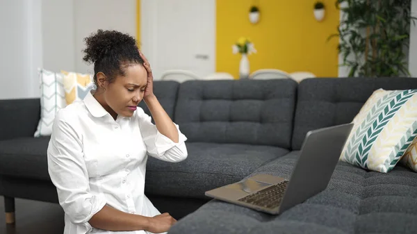 アフリカ系アメリカ人の女性が自宅でストレスの多い表情でノートパソコンを — ストック写真