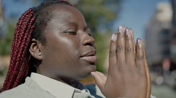 髪の毛を編んだアフリカの女性は通りで目を閉じて祈る — ストック写真