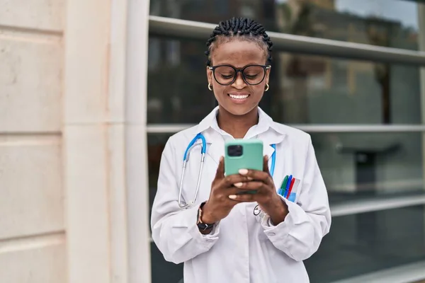 Mujer Afroamericana Doctora Sonriendo Confiada Usando Smartphone Hospital —  Fotos de Stock