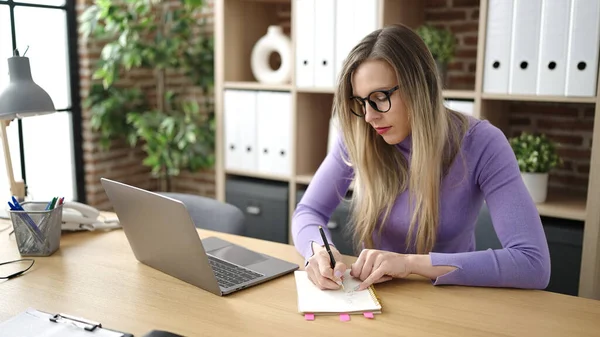 Junge Blonde Geschäftsfrau Schreibt Büro Mit Laptop Auf Notizbuch — Stockfoto