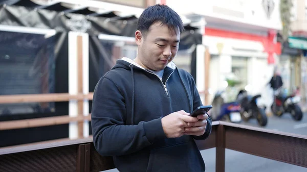 Genç Çinli Adam Sokakta Rahat Bir Ifadeyle Akıllı Telefon Kullanıyor — Stok fotoğraf