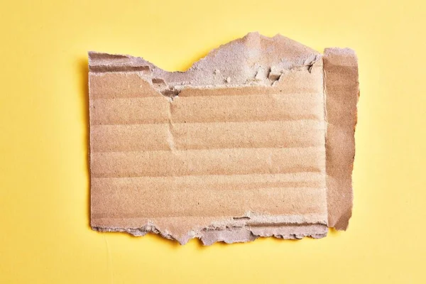 Egy Letépett Kartonpapír Elszigetelt Sárga Háttér Felett — Stock Fotó