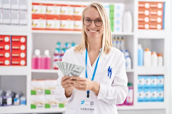 Young Blonde Woman Pharmacist Smiling Confident Holding Dollars Pharmacy — Foto Stock