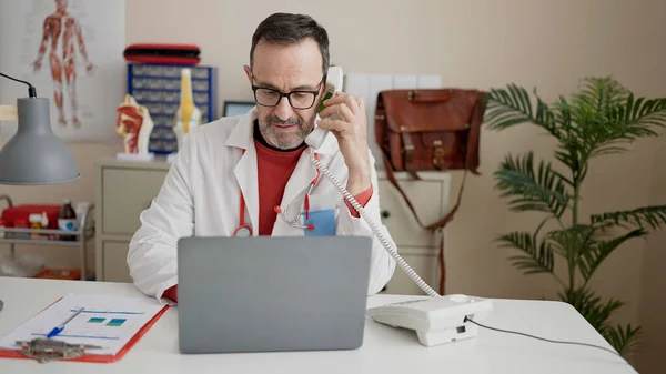 Лікар Середнього Віку Який Використовує Ноутбук Розмовляє Телефону Клініці — стокове фото