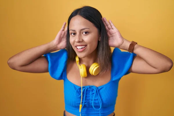 Mujer Joven Hispana Pie Sobre Fondo Amarillo Tratando Escuchar Ambos —  Fotos de Stock