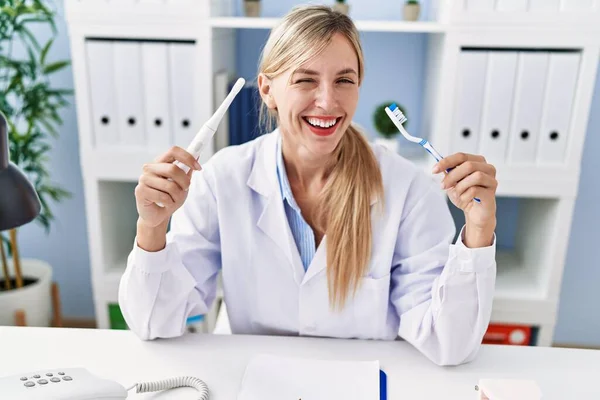 Beautiful Dentist Woman Holding Ordinary Toothbrush Electric Toothbrush Winking Looking — Stock Photo, Image