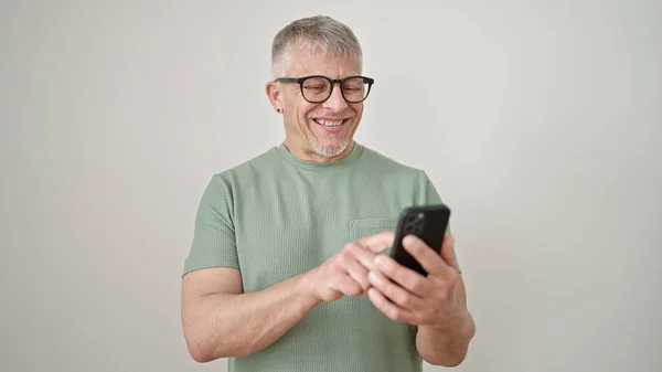 中年白发苍苍的男人 带着自信的笑容 用智能手机遮住孤立的白色背景 — 图库照片