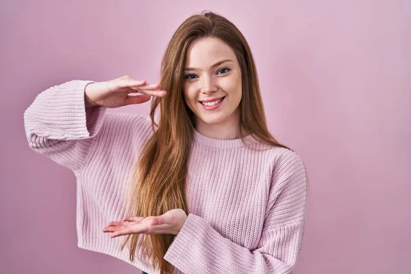 Молодая Белая Женщина Стоящая Розовом Фоне Жестикулируя Руками Показывая Большой — стоковое фото