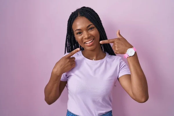 Африканская Американка Косичками Стоящая Розовом Фоне Весело Улыбаясь Показывая Пальцами — стоковое фото