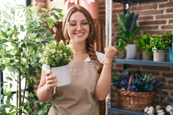Jovem Mulher Caucasiana Trabalhando Florista Loja Segurando Planta Gritando Orgulhoso — Fotografia de Stock