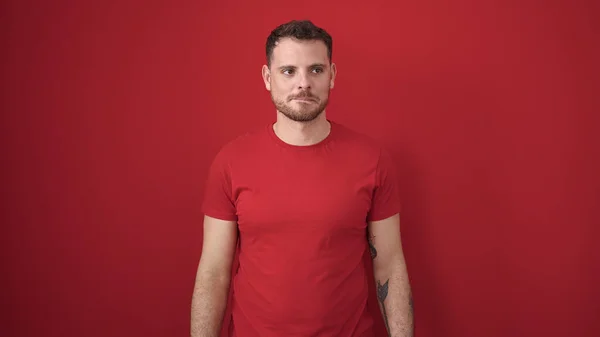 Jonge Blanke Man Met Serieuze Expressie Geïsoleerde Rode Achtergrond — Stockfoto