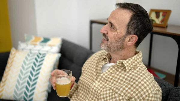 Μεσήλικας Άντρας Που Κρατάει Ένα Ποτήρι Μπύρα Καθισμένος Στον Καναπέ — Φωτογραφία Αρχείου