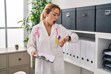 İspanyol doktor kadın saate bakıyor şaşkınlık ve şaşkınlık dolu bir ifade, korku ve heyecanlı bir yüz ifadesiyle.. 