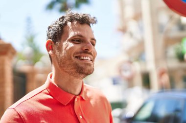 Sokakta kendinden emin gülümseyen İspanyol genç adam.