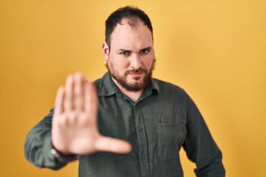 Ayrıca sarı arka planda duran sakallı İspanyol bir adam avucunun içi gibi şarkı söylemeyi kesiyor. Yüzünde olumsuz ve ciddi bir jest olan uyarı ifadesi. 