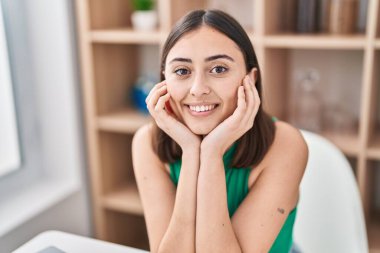 Genç İspanyol kadın masasında kendinden emin bir şekilde oturuyor.