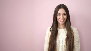 Young beautiful hispanic woman smiling confident standing over isolated pink background