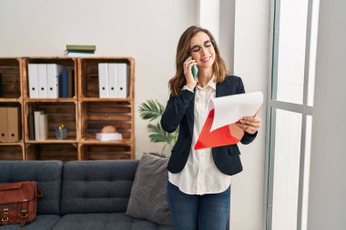 Klinikte psikoloji dersi alan genç bir kadın akıllı telefondan konuşuyor.