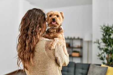 Genç, güzel, İspanyol bir kadın. Köpeğine sarılıyor.