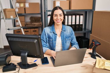 Young beautiful hispanic woman ecommerce business worker using laptop at office