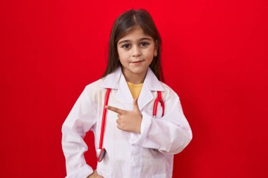 Doktor üniforması giyen küçük İspanyol kız ve steteskop gülümsüyor. 