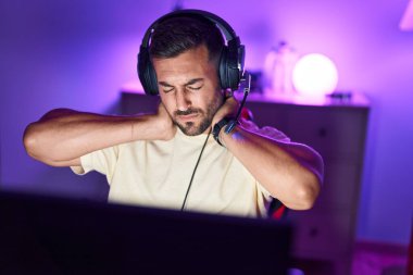 İspanyol asıllı genç adam oyun odasında bilgisayar kullanarak strese girdi.