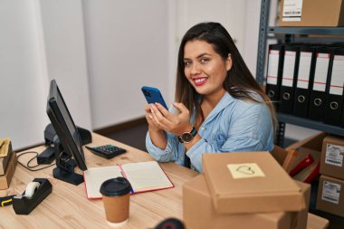 Genç, güzel ve cüsseli bir kadın. İş kadını. Ofiste akıllı telefon kullanıyor.