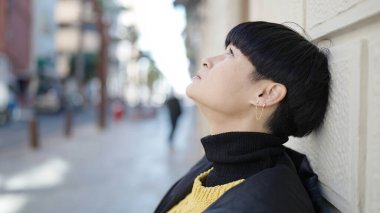 Young chinese woman standing with relaxed expression at street