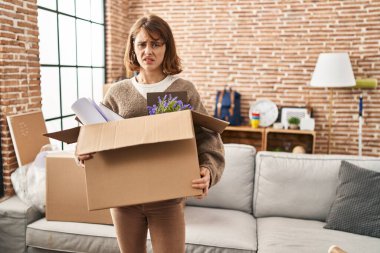 Genç ve güzel bir kadın yeni bir eve taşınıyor. Hiçbir şeyden habersiz ve kafası karışık bir yüz ifadesi. şüphe kavramı. 