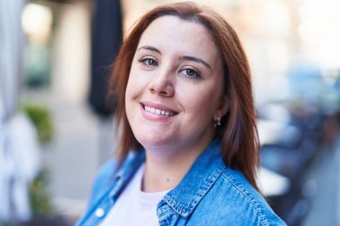 Young beautiful plus size woman smiling confident standing at coffee shop terrace